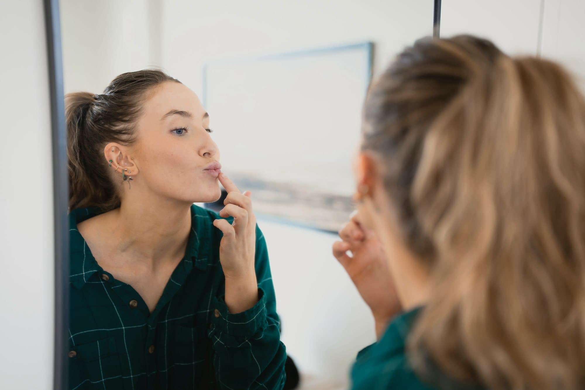 A patient studying her face in a wall mirror after treatment.