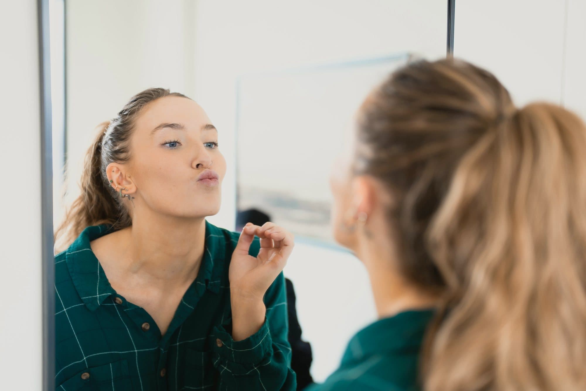 A patient blowing a kiss at her reflection in the clinic mirror after treatment.