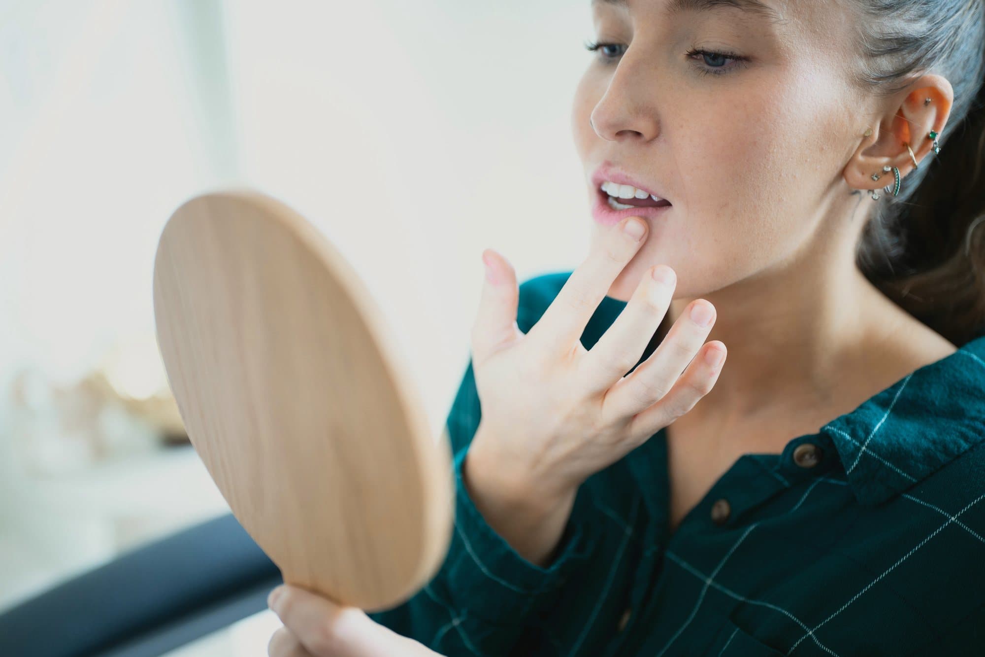 A patient checking her result in a wooden hand mirror.
